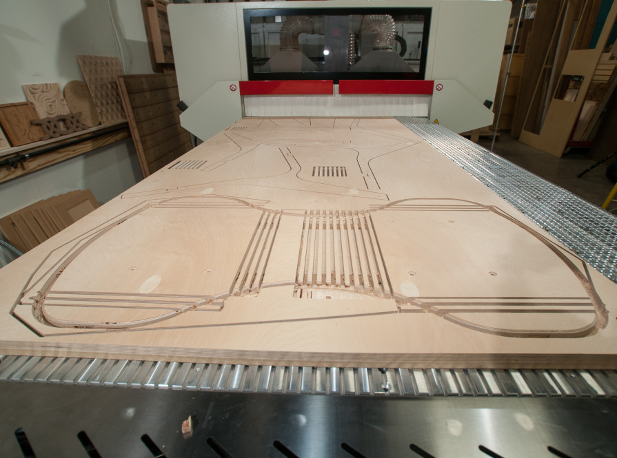 A CNC Machine cuts parts for a chart from a sheet of plywood